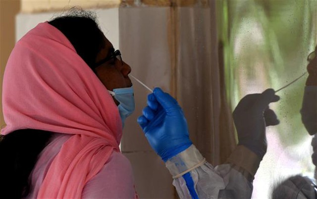 Trong ảnh: Nhân viên y tế lấy mẫu dịch xét nghiệm COVID-19 cho người dân tại Đông Delhi, Ấn Độ, ngày 24/6/2020. Ảnh: THX/TTXVN