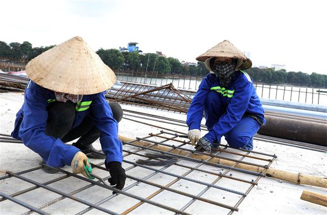 Trong ảnh: Công nhân đang làm việc tại Dự án Đầu tư xây dựng tuyến đường vành đai 3 đi thấp qua hồ Linh Đàm và nhánh kết nối với đường vành đai 3. Ảnh: Văn Điệp - TTXVN