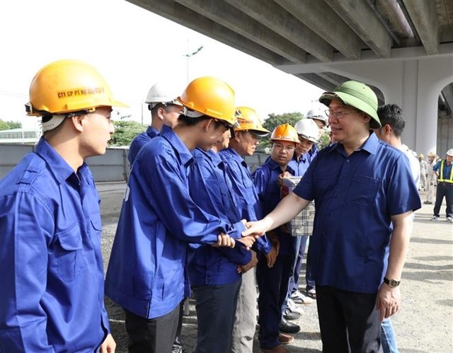 Trong ảnh: Bí thư Thành ủy Hà Nội Vương Đình Huệ thăm hỏi cán bộ, công nhân đang làm việc tại Dự án Vành đai 3 đoạn Mai Dịch - cầu Thăng Long. Ảnh: Văn Điệp - TTXVN