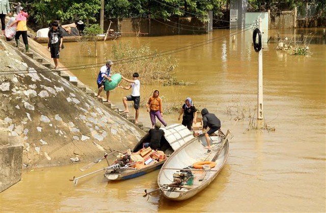 Các đoàn cứu trợ tập trung đưa những mặt hàng thiết yếu đến vùng bị nước lũ cô lập ở các xã của huyện Quảng Ninh, tỉnh Quảng Bình. Ảnh: Văn Tý-TTXVN