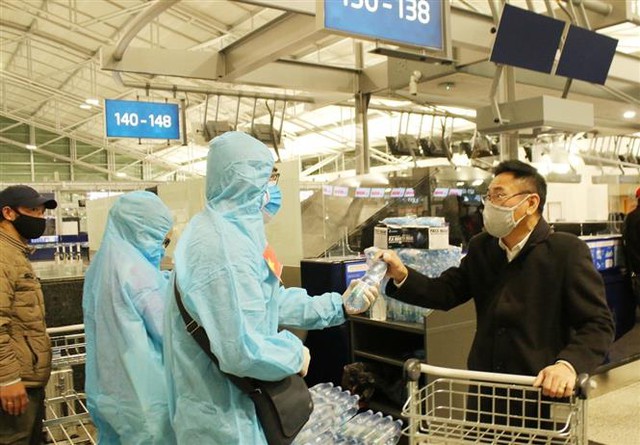 Cán bộ Đại sứ quán Việt Nam hỗ trợ nước uống, khẩu trang tại sân bay quốc tế Vaclav Havel. Ảnh: Hồng Kỳ - PV TTXVN tại Praha