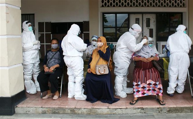 Trong ảnh: Nhân viên y tế lấy mẫu xét nghiệm COVID-19 cho người dân tại Surabaya, Indonesia ngày 8/12/2020. Ảnh: THX/TTXVN