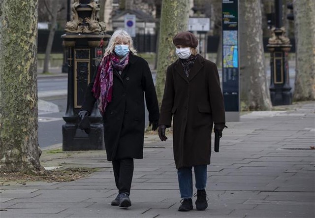  Người dân đeo khẩu trang phòng dịch COVID-19 ở London, Anh ngày 5/1/2021. Ảnh: THX/TTXVN