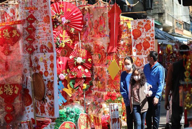 Người dân đi chợ hoa Tết truyền thống trong ngày 29 Tết Tân Sửu thực hiện nghiêm túc việc đeo khẩu trang để phòng chống dịch. Ảnh: Thanh Tùng - TTXVN