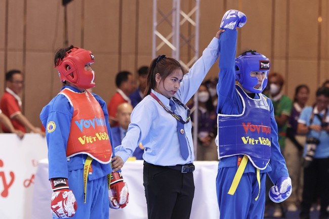 VĐV Lê Thị Hiền (giáp xanh) thi đấu xuất sắc để giành chiến thắng trước VĐV nước chủ nhà Campuchia Pech Chomno (giáp đỏ) trong trận bán kết nội dung đối kháng đơn nữ hạng 55kg. Ảnh: Minh Quyết - TTXVN