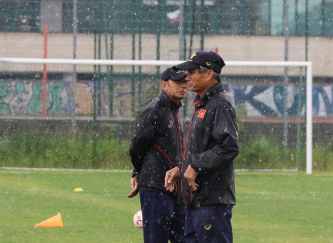 HLV Mai Đức Chung đội mưa chỉ đạo các học trò tập ở Ba Lan sáng 18/6. Ảnh: VFF