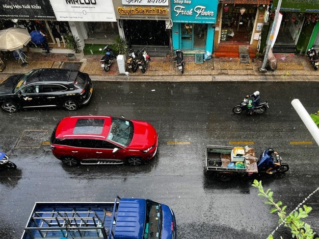 Người dân Thành phố Hồ Chí Minh đón mưa lớn 'giải nhiệt' - Ảnh 2.