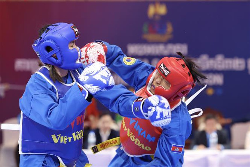 VĐV Lê Thị Hiền (giáp xanh) thi đấu xuất sắc để giành chiến thắng trước VĐV nước chủ nhà Campuchia Pech Chomno (giáp đỏ) trong trận bán kết nội dung đối kháng đơn nữ hạng 55kg. Ảnh: Minh Quyết - TTXVN