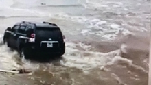 Điều khiển chiếc xe bạc tỉ đùa giỡn với sóng biển đợt mưa bão