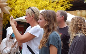 Người dân TPHCM háo hức diện áo dài đến phố ông Đồ, du khách nước ngoài thích thú trải nghiệm không khí Tết Việt Nam