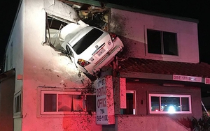 Xe ô tô bay lên rồi treo lơ lửng trên tầng 2 tòa nhà ven đường