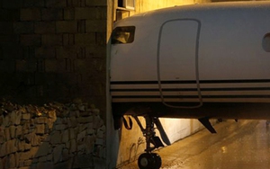 Gió mạnh, máy bay lao qua hàng rào đâm thủng tòa nhà