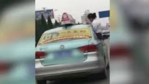 Cô bé ngồi làm bài tập trên nóc taxi khi bố đang phóng xe như bay